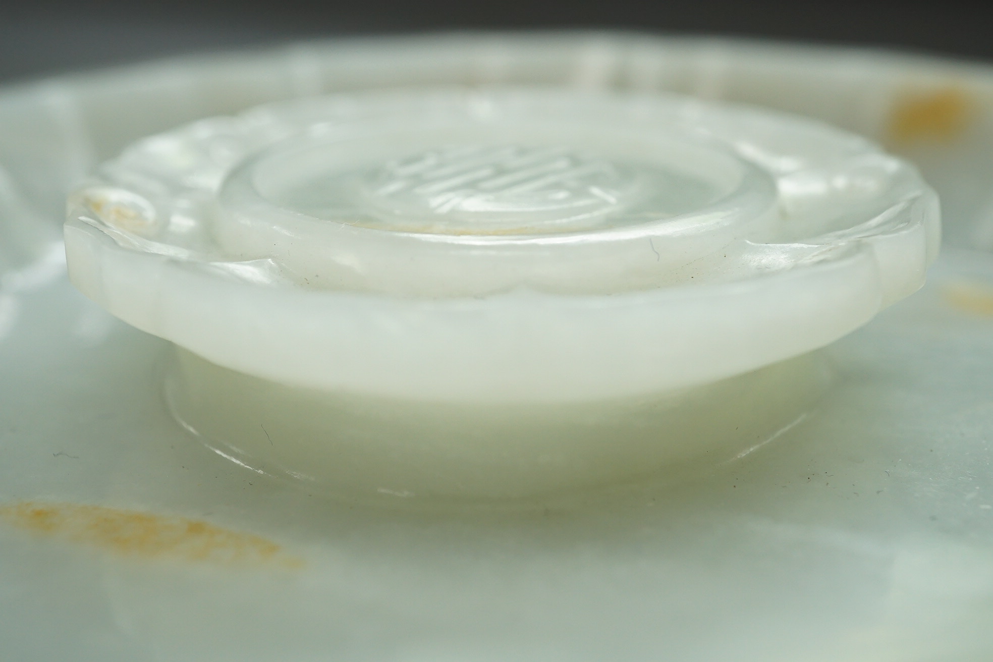 A Chinese white and russet jade petal lobed cup stand